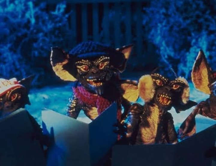 Fotograma de 'Gremlins' de 1984, en donde se muestran a las malvadas criaturas cantando villancicos.