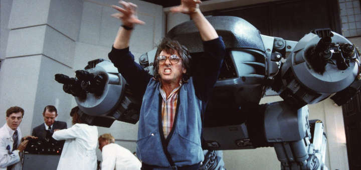 Fotograma de 'Robocop' de 1987, en donde se aprecia al director Paul Verhoeven, dirigiendo la escena en que el mortal ED-209 (Droide de Ejecución Serie 209), un robot policía mal diseñado y fuertemente armado que se descontrola durante una demostración y mata a un empleado de la OCP.
